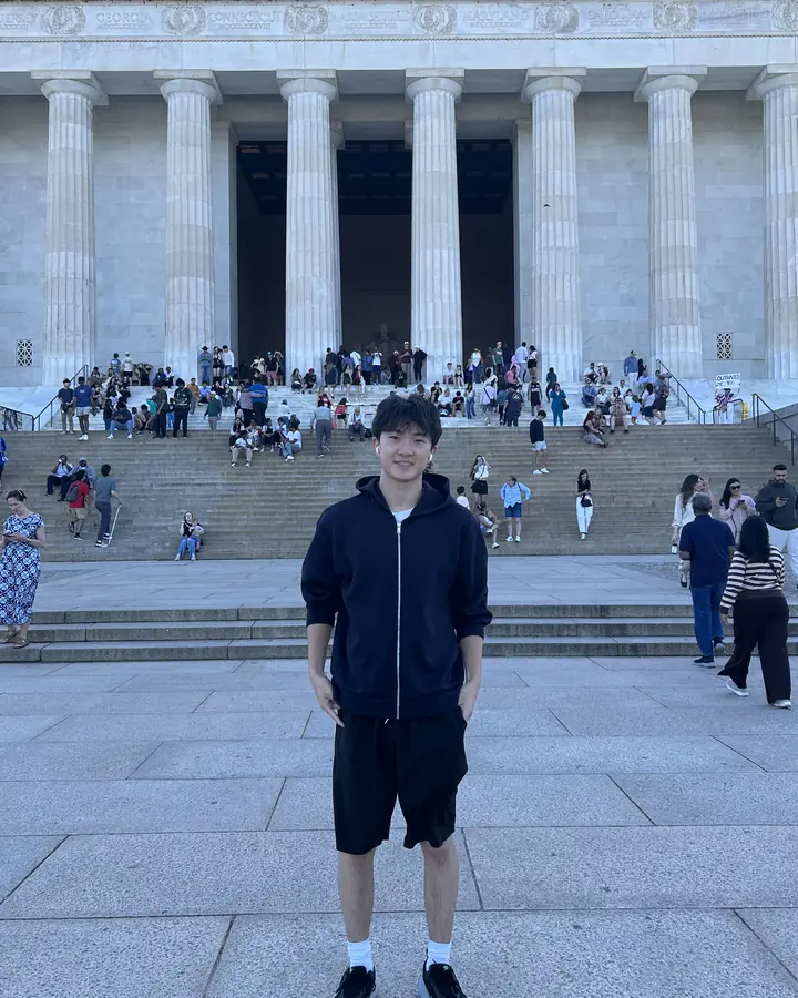 Justin standing in front of a columned memorial